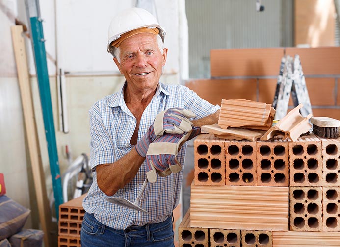 Happy bricklayer near brick stack